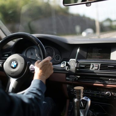 person holding BMW steering wheel