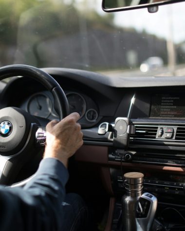 person holding BMW steering wheel