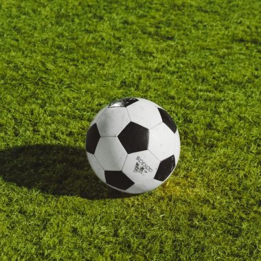 white and black soccer ball on grass field