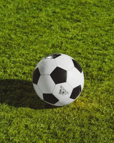 white and black soccer ball on grass field