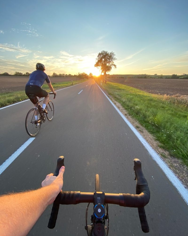 man in black shirt riding bicycle on road during daytime