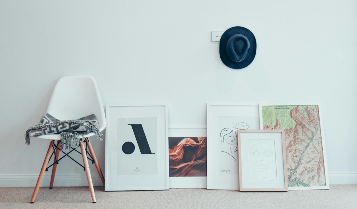 white chair beside five paintings