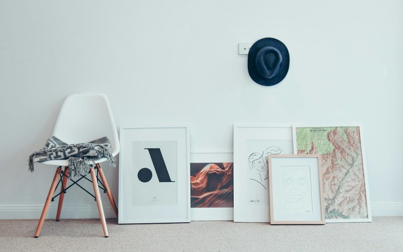 white chair beside five paintings