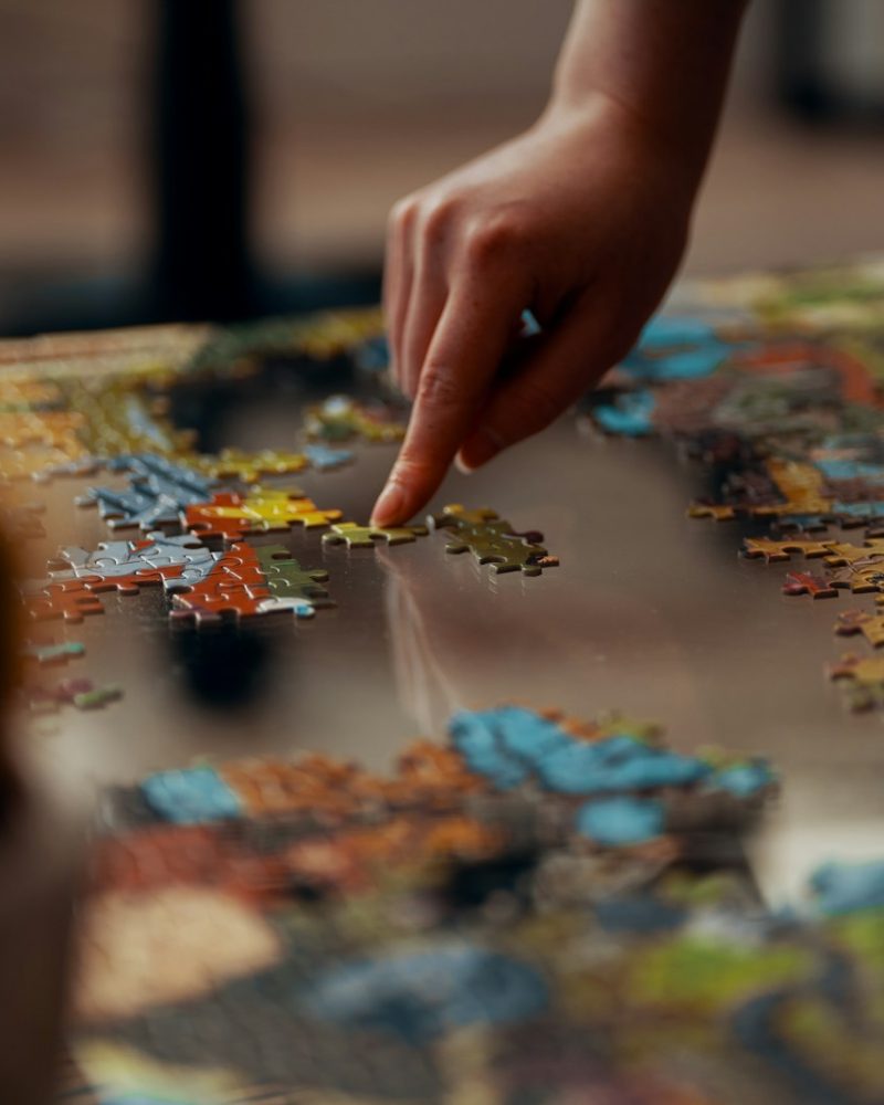 person holding jigsaw puzzle piece