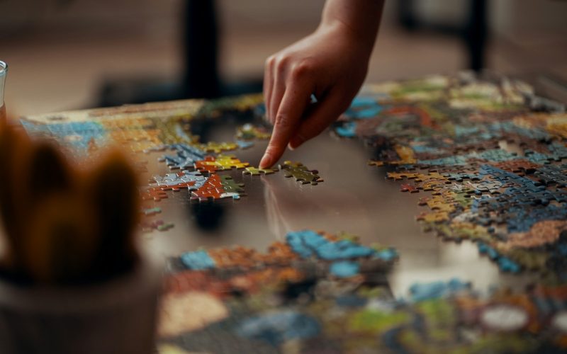 person holding jigsaw puzzle piece