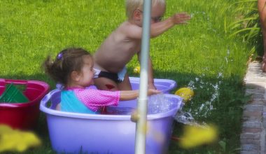 Kinderen spelen in een kleine ingerichte tuin met speelzone en terrasgedeelte